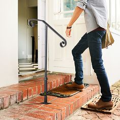 a man is walking up the stairs with his foot on the handrail and looking down