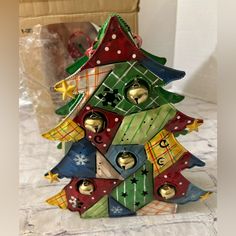 a small christmas tree made out of wooden blocks with bells on it's sides