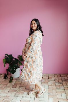 The Oakley Midi dress in a cream base with a peach and brown rose floral design is both stylish and functional. With a high neck, zipper in the back, and long sleeves with elastic cuffs, this dress is comfortable and easy to wear. The elastic waist with a tie creates a flattering silhouette, while the pleated bottom adds a touch of elegance. Model is wearing a small and is 5'8". Plus model is wearing a 2X and is 5'11". Size Chart Length Bust Waist S 47" 34" 32" M 47" 37" 34" L 47.5" 40" 36" XL 47.5" 44" 38" XXL 48" 48" 41" XXXL 48.5" 52" 44" *Measurements are approximate and are measured while hanging* Fabric and Care 100% Polyester Hand wash cold. Do not bleach. Lay flat to dry. Low iron if needed or dry clean. Tiered Dresses, Plus Model, Teen Dress, Hanging Fabric, Cream Base, Spring Fits, White Outfits, Jeans Dress, Floral Maxi Dress