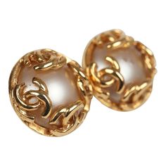 These 1995 vintage Chanel round CC pearl earrings feature a single pearl in the center of the earring with four mini CC logo motifs around the pearl and a clip on back closure with 24K gold plated hardware. Origin: FranceCondition: Vintage; Very Good - The pearl is visibly scratched on one of the earrings. Accompanied by: Chanel jewelry boxMeasurements: .95" height x .95" width Round Pearl Earrings, Pearl Earrings Gold, Single Pearl, Gold Pearl Earrings, Chanel Jewelry, The Pearl, Cc Logo, Vintage Chanel, Earrings Gold