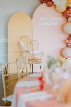 a chair sitting next to a table with balloons on it