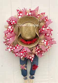 a scarecrow hat hanging on the side of a white wall with red and white polka dots