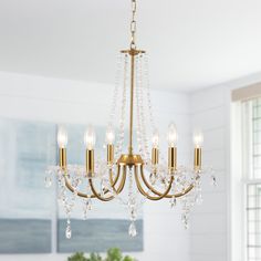 a chandelier hanging from the ceiling in a room with white walls and windows