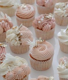 there are many cupcakes with pink frosting and white icing on them