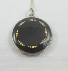 Formal Enamel Locket Jewelry, Engraved Black Enamel Jewelry, Silver Pendant With Black Enamel, Polished Enamel Medallion Jewelry, Enamel Round Pendant Locket Jewelry, Engraved Medallion Jewelry In Enamel, White Gold Necklace With Black Enamel, Silver Enamel Locket Necklace, Vintage Silver Jewelry With Black Enamel