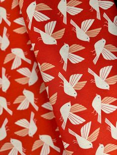 two red and white fabric with birds on them