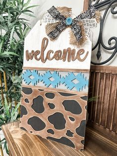 a wooden welcome sign sitting on top of a table