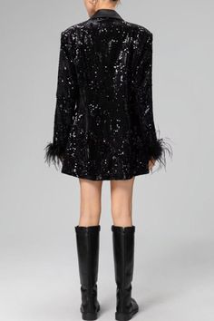 the back view of a woman wearing a black sequin jacket and knee high boots