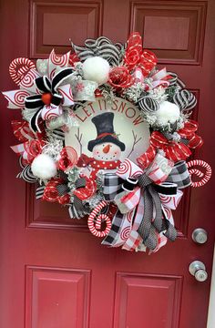 a christmas wreath with candy canes and an image of a snowman on it