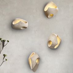 three white vases sitting next to each other on a wall