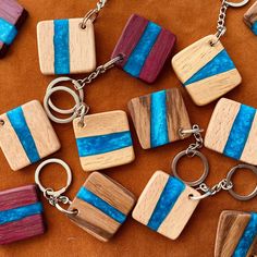 several pieces of wood with blue and red stripes on them are being displayed as key chains