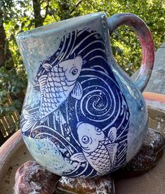 a blue and white vase sitting on top of a table next to doughnuts