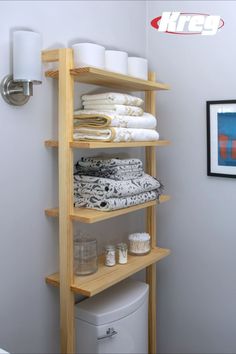 a bathroom shelving unit with towels and toilet paper