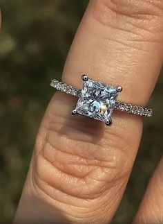 a woman's engagement ring with a princess cut diamond