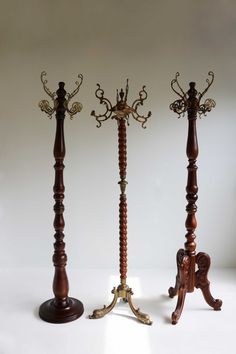 three wooden candlesticks with ornate designs on each one and a candle holder in the middle