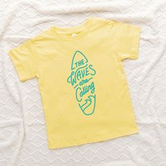 Looking for a cute tee for your kids? We have the perfect The Waves Are Calling Surf Board graphic tee addition to their closet! Also available in youth tees. Trendy Cotton T-shirt For Playwear, Cotton T-shirt With Cartoon Print For Playwear, Fun Graphic Print T-shirt For Playwear, Casual T-shirt With Letter Print For Play, Casual Letter Print T-shirt For Play, Family Matching Summer T-shirt With Screen Print, Summer Cartoon Print Playwear T-shirt, Family Matching Cartoon Print T-shirt For Summer, Graphic Tee Tops With Letter Print For Playwear