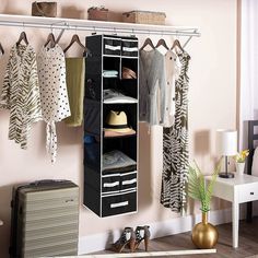 an organized closet with clothes and shoes hanging on the wall next to a white table