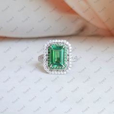 an emerald and diamond ring set in white gold