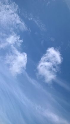 an airplane flying high in the sky with clouds