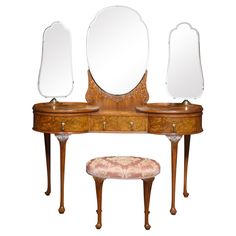 an antique dressing table with mirror and stool