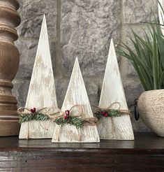 three small wooden christmas trees on a table