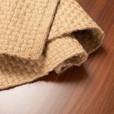 two pieces of cloth on top of a wooden table with wood grained surface and brown staining