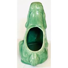 a green frog shaped vase sitting on top of a table