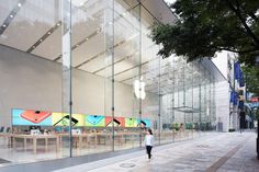 an apple store with people walking by it