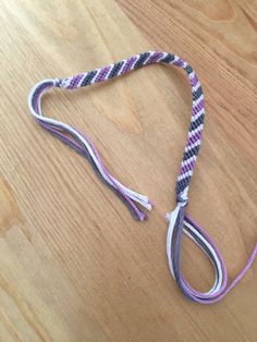 a purple, white and black leash laying on top of a wooden floor