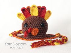 a crocheted hat with a bird on it's head and tassel