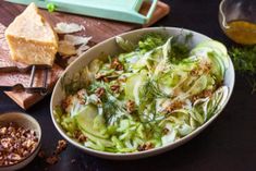 a bowl filled with lettuce next to bread and other food on a table