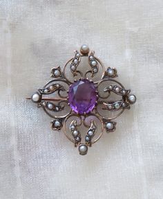 Antique Edwardian brooch. 9 Carat Gold - stamped 9ct - dates to early 1900s. Original antique gemstones - Amethyst and Seed Pearls. Maker's mark is G&W. Fabulous estate clearance item with original patina. Measures 2.5cm square. Will arrive in the box shown. Please see photos. Fast dispatch worldwide. I combine postage for multiple purchases. Returns accepted if not satisfied - buyer pays return postage. Feel free to ask questions about items. Plenty of items in my shop - if you are looking for Heirloom Oval Gemstone Brooches, Elegant Amethyst Brooches For Wedding, Ornate Oval Brooch For Formal Occasions, Heirloom Oval Brooch For Formal Occasions, Ornate Oval Brooches For Formal Occasions, Heirloom Style Oval Filigree Brooch, Heirloom Filigree Oval Brooch, Heirloom Oval Filigree Brooch, Purple Gemstone Brooches For Weddings