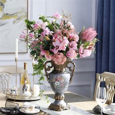 a vase filled with pink flowers sitting on top of a table