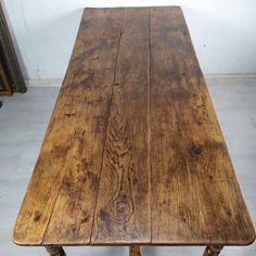 an old wooden table sitting on top of a tile floor