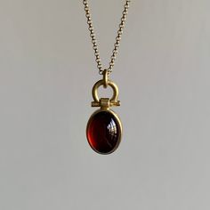 Oval Garnet Cabochon Pendant – Meeka Fine Jewelry Polished Yellow Gold Garnet Jewelry, Yellow Gold Garnet Jewelry With Polished Finish, Polished Garnet Gold Jewelry, Elegant Gold Garnet Cabochon Jewelry, Yellow Gold Garnet Necklaces With Oval Shape, Yellow Gold Oval Garnet Necklace, Gold Oval Garnet Necklaces, Oval Garnet Gold Necklace, Newport Ri