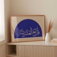 an arabic calligraphy is displayed on a wall above a shelf in a living room