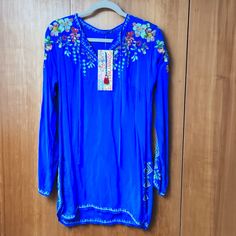 Beautiful Tunic Top From Johnny Was. Base Color Is Blue, With Colorful Floral Embroidery, On The Front, Sleeves, And Along Border. This Item Is Brand New, Has Never Been Worn. The Size Is Small. Casual Blue Embroidered V-neck Top, Blue V-neck Top With Floral Embroidery, Blue Fitted Floral Embroidered Top, Blue Floral Embroidered Summer Blouse, Blue Floral Embroidery Blouse For Summer, Blue Embroidered Top For Summer Beach, Spring Blue Embroidered Top For Beach, Blue Floral Embroidery Top For Vacation, Blue Embroidered Top For Spring Beach Occasion