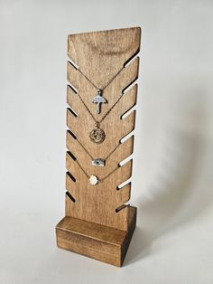 a wooden display with several different necklaces on it's sides and an arrow in the middle