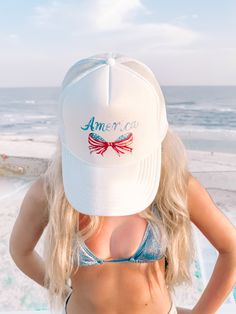 Get patriotic and stylish with the America Bow Hat from Sassy Shortcake! This white, trucker style hat features a mesh design, text that reads america, and a bow made of the American flag. Show off your love for the USA in a unique and playful way. White Trucker Baseball Cap For Beach, White Trucker Hat For The Beach, Summer Patriotic Trucker Hat With Curved Brim, Patriotic White Hat For Summer, White Baseball Cap For 4th Of July, White Trucker Hat For Summer, Patriotic Trucker Hat For 4th Of July, Summer White Mesh Hats, Patriotic Adjustable Trucker Hat For 4th Of July