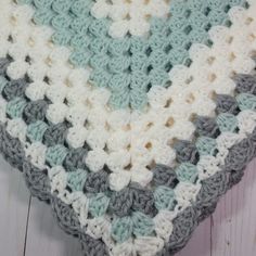 a crocheted blanket sitting on top of a wooden floor