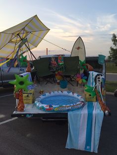 the back of a truck with decorations on it's bed and an inflatable pool