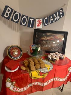 a table topped with cookies and pastries next to a sign that says boot camp