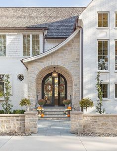 the front entrance to a large white brick house