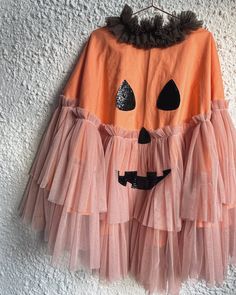 Peach pumpkin mini tie back cape. Made from soft peach cotton, peach tulle ruffles and black glitter vinyl fabric  finished with green cotton tie (to be worn at the back of the neck)  Wear peach/black wet look leggings/cycling shorts with a peach short/long sleeved tee underneath. please note fabric colours may change slightly if i cant get the exact colours pictured.  kid size, 45cm in length  age 1-4 years (We can make it longer/larger for an additional cost) handmade in the uk  keep away from School Halloween Costumes, Creative Halloween Costumes Diy, Classy Halloween Decor, Costume Capes, Tulle Ruffles, Peach Shorts, Pumpkin Outfit, Wet Look Leggings, Pumpkin Costume