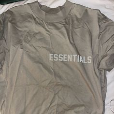 New Never Worn Essentials T-Shirt Sand Color Oversized Oversized Logo Print Tops For Summer, Spring Graphic Tee With Drop Shoulder, Casual Drop Shoulder Tops With Letter Print, Essential Cotton Spring Tops, Essential Cotton Tops For Spring, Casual Drop Shoulder Top With Text Print, Urban Gray Tops For Spring, Essential Summer Crew Neck Top, Spring Oversized Tops With Logo Print