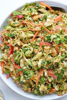 a bowl filled with broccoli, carrots and cashew sprouts