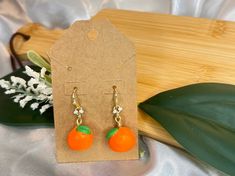 These vibrant earrings feature handcrafted oranges made from polymer clay, capturing the fresh, sunny essence of summer, adding fun to any occasion or outfit Orange Earrings For Summer Gifting, Summer Orange Jewelry With Fruit Design, Handmade Orange Earrings For Summer, Summer Gift Earrings In Polymer Clay, Summer Gift Polymer Clay Earrings, Summer Polymer Clay Earrings For Gifts, Orange Dangle Earrings In Polymer Clay, Orange Dangle Earrings Polymer Clay, Peach Earrings For Summer Gift