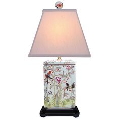 a lamp that is on top of a table with a bird and flower design on it