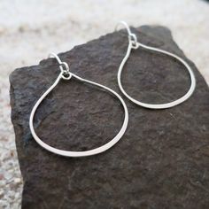 "These beautiful sterling silver teardrop hoop earrings are the perfect accessory for any outfit. Crafted from 925 sterling silver, their classic teardrop shape is accented by the sterling silver ear wires, adding a touch of sophistication to any look. These earrings are incredibly versatile and can be worn day or night for any occasion. With their timeless design, these earrings are sure to be a favorite for years to come. DETAILS - Materials: .925 sterling silver - Dimensions: - 25x25mm - Leng Teardrop Hoop Earrings, Sterling Silver Hoops, Earrings Sterling Silver, Silver Hoops, Ear Wire, Minimalist Jewelry, Ear Wires, Sterling Silver Earrings, Jewelry Earrings Dangle