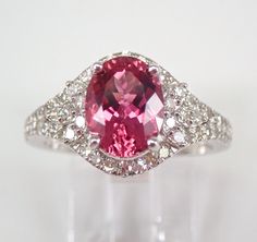 14K White Gold Diamond and Pink Tourmaline Engagement Ring. The ring is set with one genuine Oval Pink Tourmaline in the center and seventy natural Round Brilliant Diamonds. The Pink Tourmaline measures 9 X 7 mm and weighs 2 carats. The diamonds in this ring are G/H color, SI clarity and weigh a total of .85 carat. This ring is 14KT White Gold, weighs 4.5 grams and is a finger size 7, which is resizable free of charge (please inquire about sizing with the finger size you need). This ring will be accompanied by an appraisal by a GIA Certified Diamond Grader with the retail replacement value of $4,285.00. I will ship this ring promptly in a gift box. ADDITIONAL REQUESTS If you would like to see more pictures of this item, please let us know and we would be happy to provide them for you. Plea Gia Certified Tourmaline Jewelry For Anniversary, Oval Pink Diamond Engagement Ring, Pink Tourmaline Engagement Ring, Pink Diamond Engagement Ring, Tourmaline Engagement Ring, Engagement Sets, Engagement Ring Sizes, White Gold Engagement, Pretty Earrings